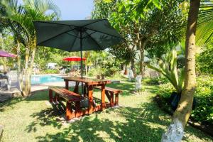a picnic table with an umbrella next to a pool at Ilha Azul in Ponta do Ouro