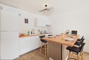 a kitchen with a wooden table and some chairs at Marguerite in Bédée
