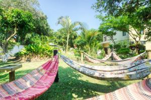 two hammocks on the grass in front of a building at Ilha Azul in Ponta do Ouro