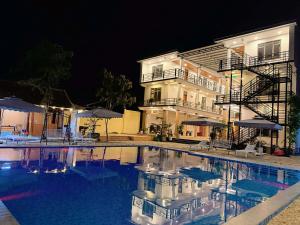 a swimming pool in front of a building at night at Jade River Phong Nha in Phong Nha