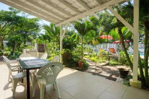 a table and chairs on a patio with palm trees at Ilha Azul in Ponta do Ouro