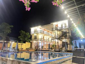 a hotel with a swimming pool in front of a building at Jade River Phong Nha in Phong Nha +22 photos