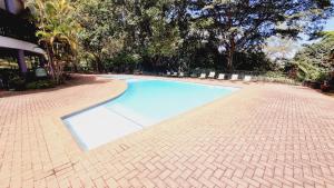 a blue swimming pool on a brick road at Azalea at Greenway Woods in White River