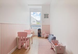 a childs room with pink chairs and a table at Marguerite in Bédée