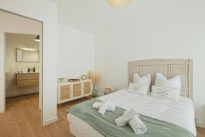 a bedroom with a large white bed with towels on it at Marguerite in Bédée