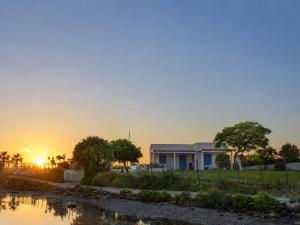 a house with the sunset in the background at Baia dei Fenici in Birgi Vecchi