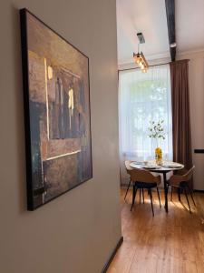 a dining room with a table and a painting on the wall at Urban Loft Studio 33 in Daugavpils