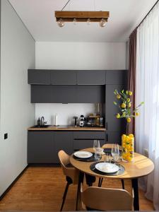a kitchen with a wooden table with chairs and a dining room at Urban Loft Studio 33 in Daugavpils