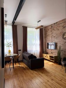 a living room with a black couch and a table at Urban Loft Studio 33 in Daugavpils