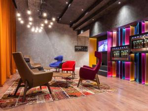 a waiting room with colorful chairs and wine bottles at ibis Tbilisi Stadium in Tbilisi City