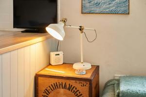 a lamp on top of a wooden box with a tv at The Bamburgh Bolthole in Bamburgh