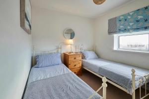 two twin beds in a bedroom with a window at The Bamburgh Bolthole in Bamburgh