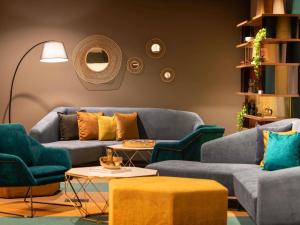 a living room with blue couches and chairs at Mercure Canberra Belconnen in Canberra