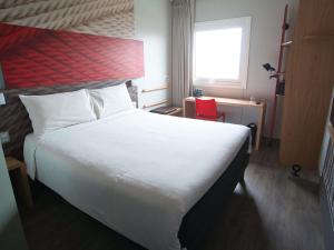 a bedroom with a large white bed and a window at ibis Trujillo in Trujillo