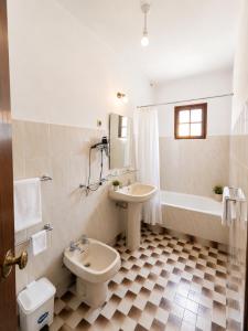 a bathroom with two sinks and a toilet and a tub at Serrana Gerês Inn in Geres +36 photos