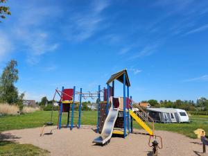 a playground with a slide in a park at Stuga 21 i Dalskärs Camping in Bergkvara