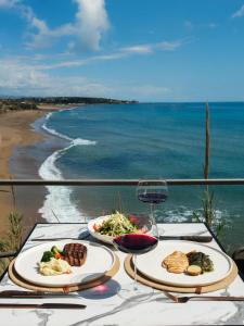 a table with two plates of food and a glass of wine at 6 ROOMS By ZULA in Side