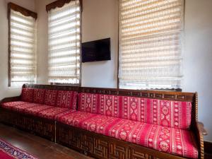a red couch in a room with two windows at AKİFBEY KONAĞI in Kastamonu