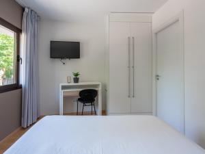 a bedroom with a white bed and a tv at Limehome Barcelona Carrer de Fontcoberta - Digital Access in Barcelona