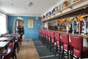 a bar with red chairs in a restaurant at The Portaferry Hotel in Portaferry