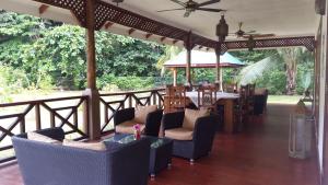 a porch with chairs and a table on a deck at Paodise Guesthouse in La Digue