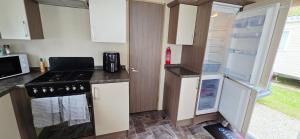 a small kitchen with a stove and a refrigerator at The Minver - Park Dean Resort in Saint Minver +2 photos