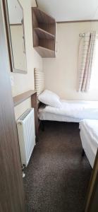a small room with two beds and a mirror at The Minver - Park Dean Resort in Saint Minver