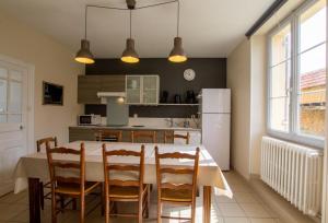 a kitchen with a table and chairs and a refrigerator at Gîte brisset in Coulaures