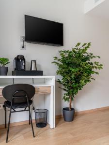 a desk with a chair and a tv on a wall at Limehome Barcelona Carrer de Fontcoberta - Digital Access in Barcelona +43 photos