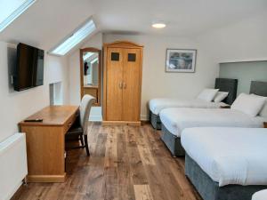 a room with three beds and a desk and a tv at Henehan's Town House in Westport +8 photos