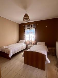 a bedroom with two beds and a window at Villa Apanemi in Kala Nera