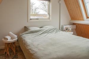 a small bedroom with a bed and a window at Duinhuis Zout Hout in Egmond-Binnen