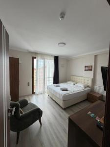 a bedroom with a large bed and a chair at LUXOR RESIDENCE in Trabzon +13 photos