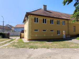 a yellow house with a brown roof at Deák Houses in Nagykőrös