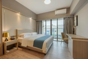 a hotel room with a bed and a desk at Foshan Poltton International Serviced Apartment in Foshan +51 photos