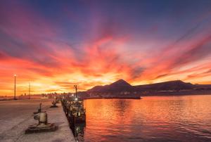 a sunset over a body of water with a mountain at Casa Juanca in Comodoro Rivadavia +18 photos