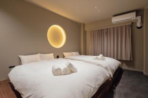 a bedroom with a large bed with towels on it at SOSHIJI Arashiyama in Kyoto