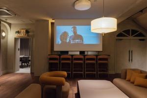 a living room with a tv and a couch and chairs at SOSHIJI Arashiyama in Kyoto