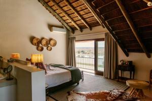 a bedroom with a bed and a balcony at Buhala Lodge in Malelane +67 photos