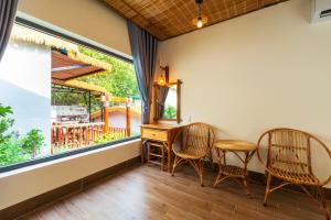 a room with two chairs and a desk and a window at Mango Village in Phú Quốc