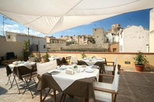 a restaurant with tables and chairs on a balcony at Bed and Breakfast Welcome in Noto