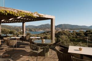 a patio with tables and chairs and a view at L'Hostellerie du Moulin des Oliviers in Olmeto +52 photos