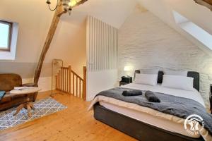 a bedroom with a large bed in a attic at Le petit cottage in Ruffiac