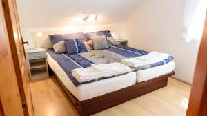 a bedroom with a large bed with blue and white sheets at Magyar Tenger Pihenőház, for 2-8 person, 105 m2, garden, pool, free parking, 5 min from the Lake, Balatonakarattya in Balatonakarattya +39 photos