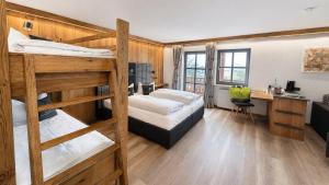 a bedroom with two bunk beds and a desk at Familotel Der Böhmerwald in Eschlkam +18 photos