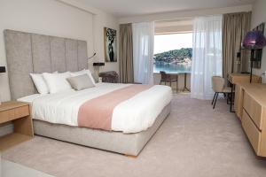 a bedroom with a large bed with a desk and a kitchen at Hotel M in Zaton