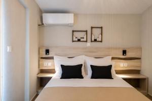 a bedroom with a bed with black and white pillows at Casale Luxury House - Luxury Garden Maisonettes in Nikiti