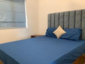 a bedroom with a bed with blue sheets and blue pillows at Arkad Golf Residence in Gonapola