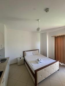 a small bedroom with a bed with white sheets at Villa Noah in Ksamil
