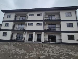 a large white building with balconies and a courtyard at Apartamente 2026 in Fălticeni